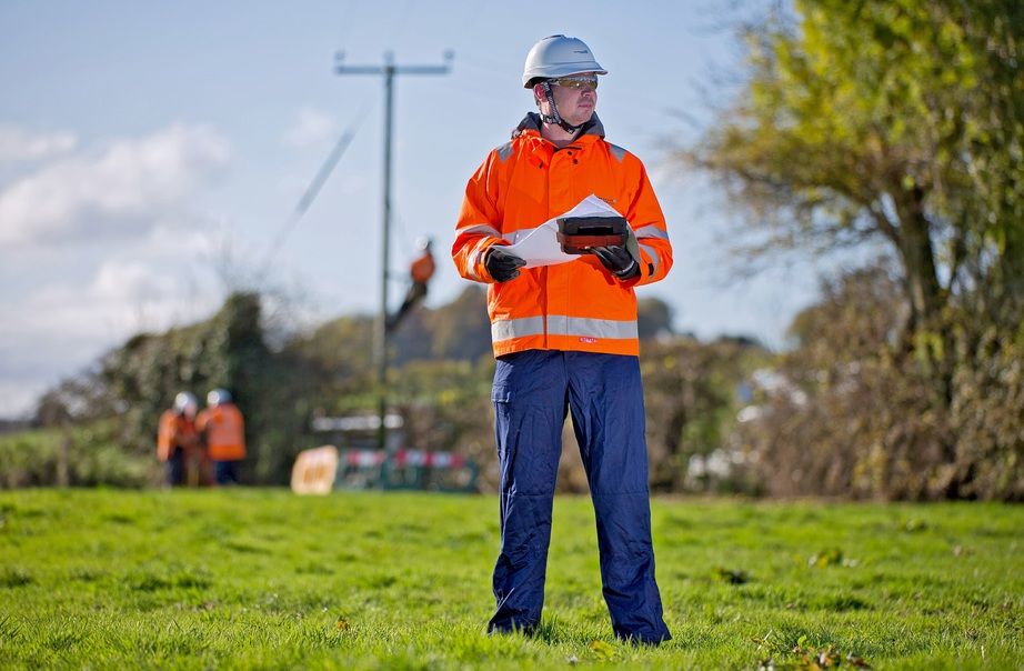 WPD engineer in a field holding plans
