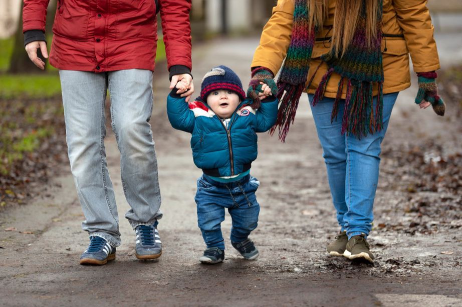 Parents walking with baby in the middle
