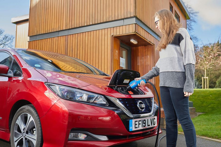 Woman charging red electric car