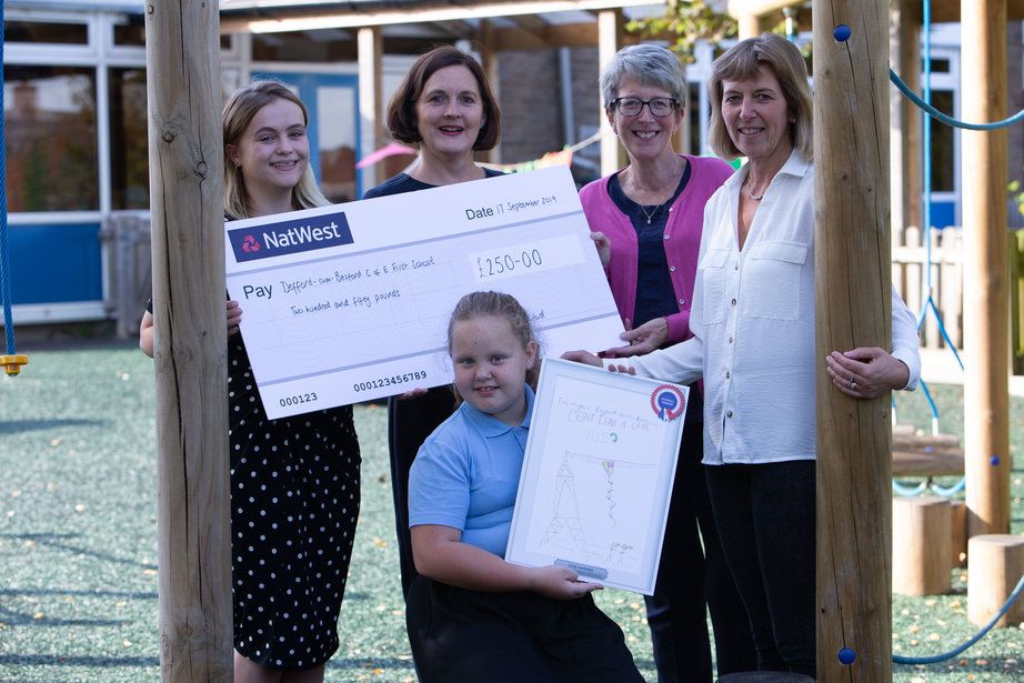 Teachers and pupil pose with a cheque